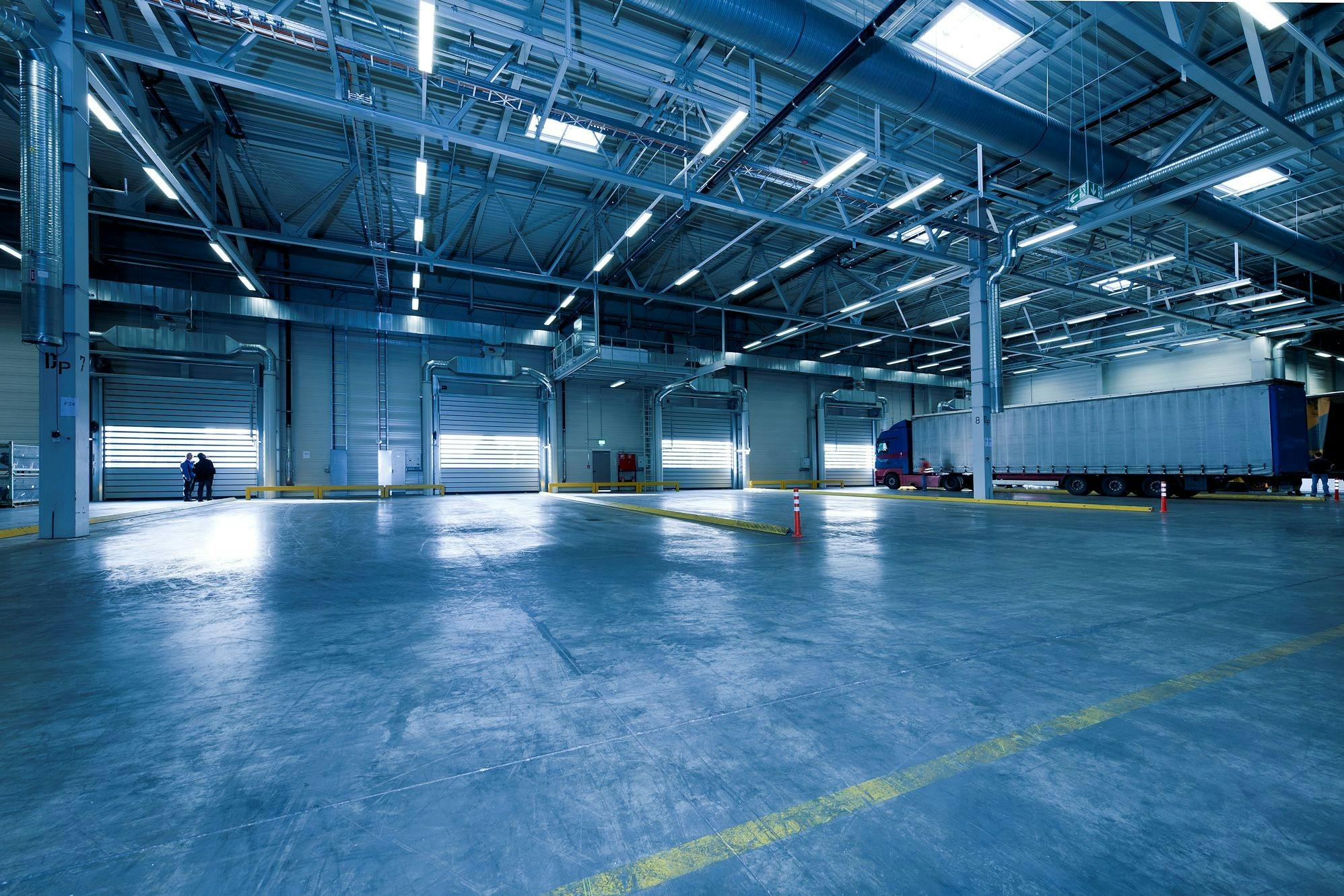 Specialized Refrigerated & ADR Freight at Loading Dock Auto-Stop ADR‑capable refrigerated trucks at a logistics center loading dock, ready for temperature‑controlled European transport.